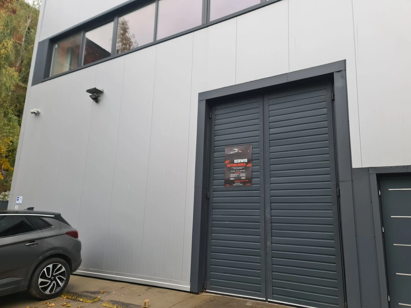 Wejście do hali serwisowej AutoKlinika Łódź – brama wjazdowa i oznaczenie warsztatu